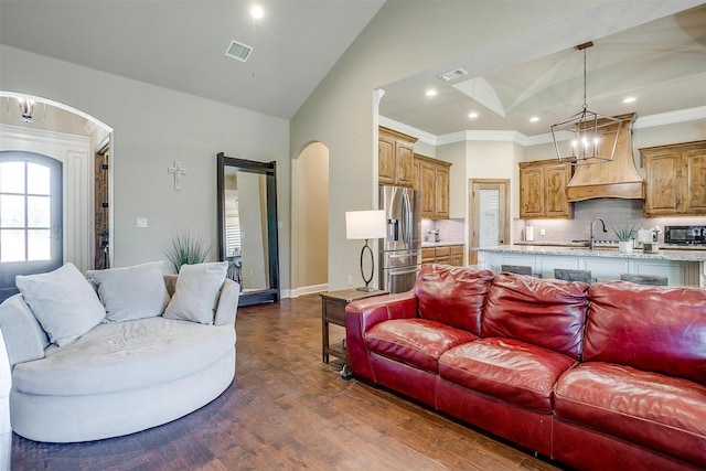 3201 Steamers Ct, Granbury, TX 76049 - living area featuring arched walkways, dark wood finished floors, crown molding, a chandelier, and recessed lighting