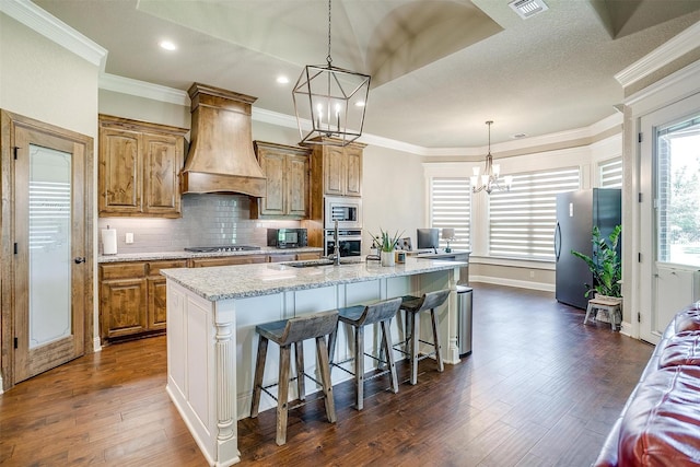 3201 Steamers Ct, Granbury, TX 76049 - kitchen with custom exhaust hood, stainless steel appliances, a chandelier, dark wood-type flooring, and recessed lighting