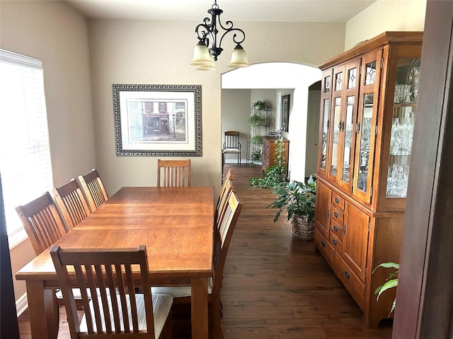 2663 Rodeo Dr, Quinlan, TX 75474 - dining area featuring dark wood finished floors, a chandelier, and arched walkways