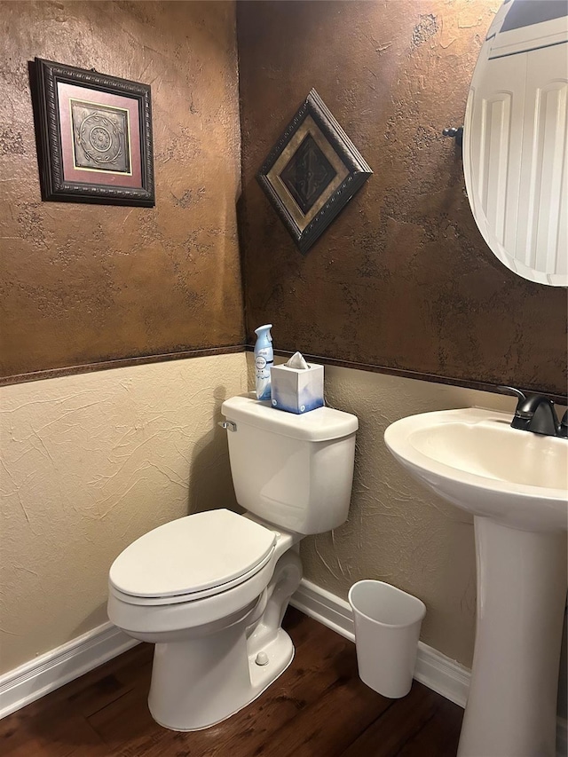 2663 Rodeo Dr, Quinlan, TX 75474 - half bath with wood finished floors, toilet, and baseboards