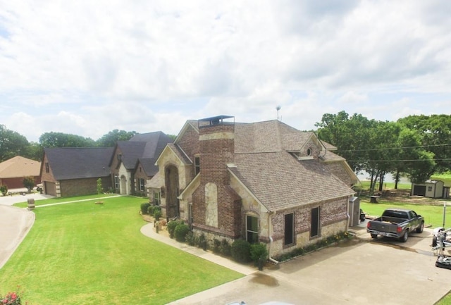 2663 Rodeo Dr, Quinlan, TX 75474 - view of front facade featuring stone siding, concrete driveway, a front yard, and a shingled roof