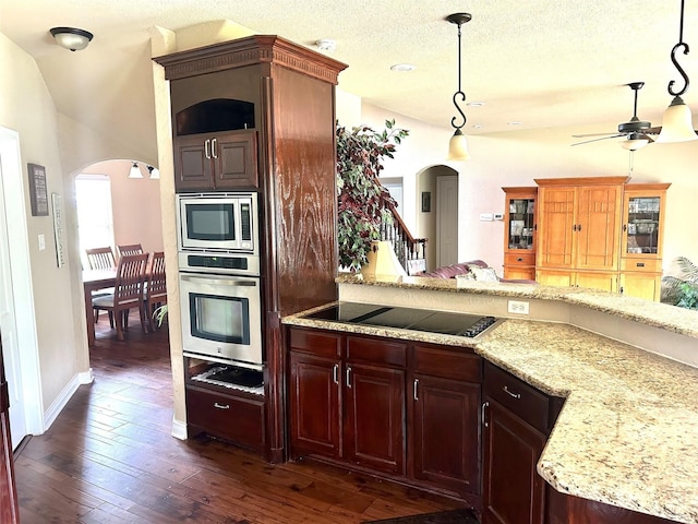 2663 Rodeo Dr, Quinlan, TX 75474 - kitchen featuring stainless steel appliances, arched walkways, ceiling fan, and dark wood-style floors