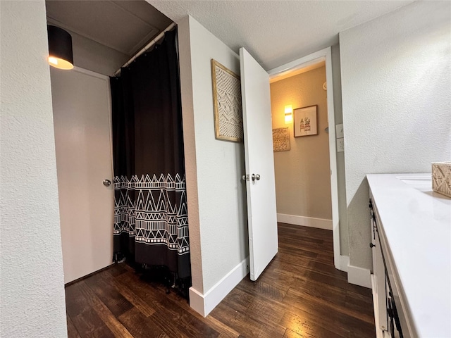 6014 Mcafee Dr, The Colony, TX 75056 - corridor featuring dark wood-style floors, baseboards, and a textured wall