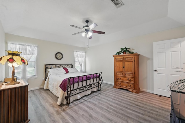 685 Cardinal Ridge Rd, Burleson, TX 76028 - bedroom with light wood-type flooring, multiple windows, baseboards, and a tray ceiling