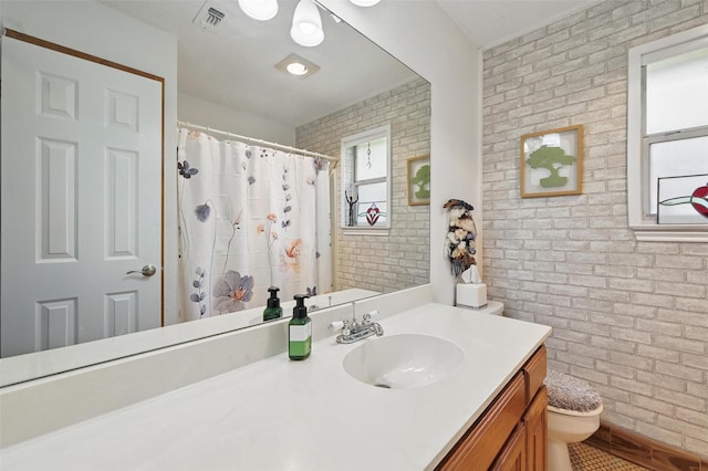 685 Cardinal Ridge Rd, Burleson, TX 76028 - full bathroom with brick wall, toilet, vanity, and curtained shower