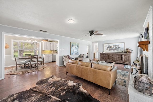 815 N Spikes Rd, Corsicana, TX 75110 - living area featuring a chandelier, a ceiling fan, wood finished floors, ornamental molding, and a brick fireplace