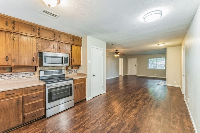 311 Franklin Dr, Euless, TX 76040 - kitchen with appliances with stainless steel finishes, brown cabinets, decorative backsplash, light countertops, and open floor plan