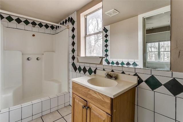 802 S Rusk St, Weatherford, TX 76086 - full bathroom featuring vanity, tile patterned floors, tile walls, and washtub / shower combination