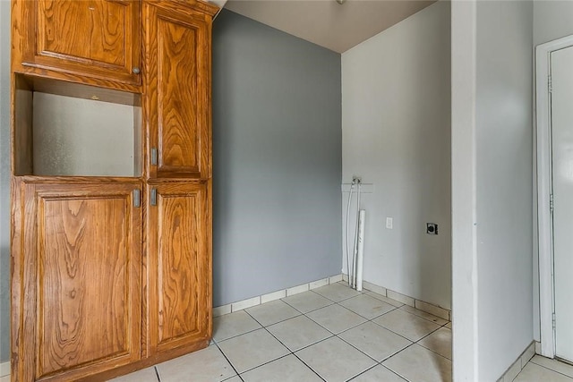 802 S Rusk St, Weatherford, TX 76086 - kitchen featuring light tile patterned flooring, baseboards, and brown cabinetry