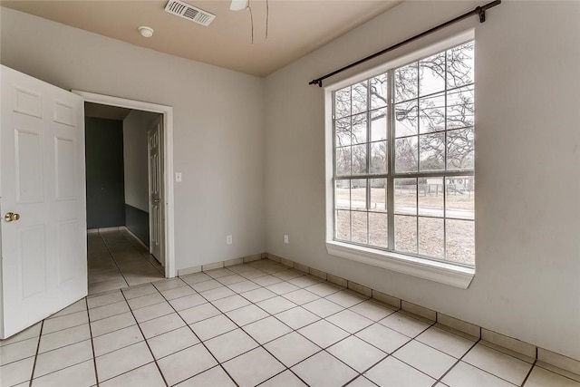 802 S Rusk St, Weatherford, TX 76086 - empty room with healthy amount of natural light, light tile patterned flooring, and a smoke detector