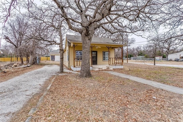 802 S Rusk St, Weatherford, TX 76086 - bungalow featuring a porch, a shingled roof, and driveway