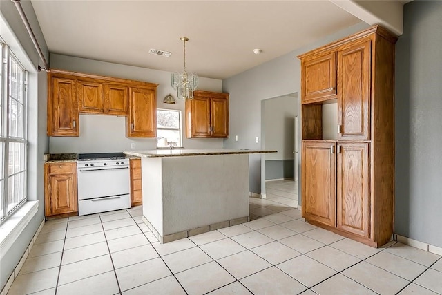 802 S Rusk St, Weatherford, TX 76086 - kitchen with white range with gas cooktop, brown cabinetry, and light tile patterned floors