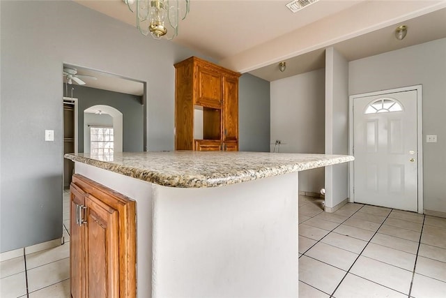 802 S Rusk St, Weatherford, TX 76086 - kitchen with light tile patterned floors, brown cabinets, baseboards, and ceiling fan