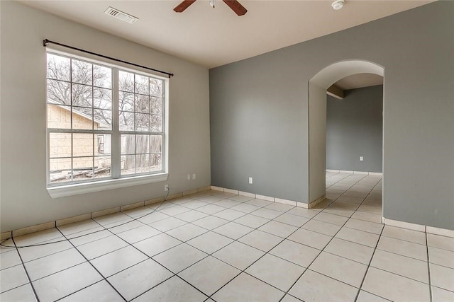802 S Rusk St, Weatherford, TX 76086 - empty room featuring ceiling fan, arched walkways, healthy amount of natural light, and light tile patterned floors