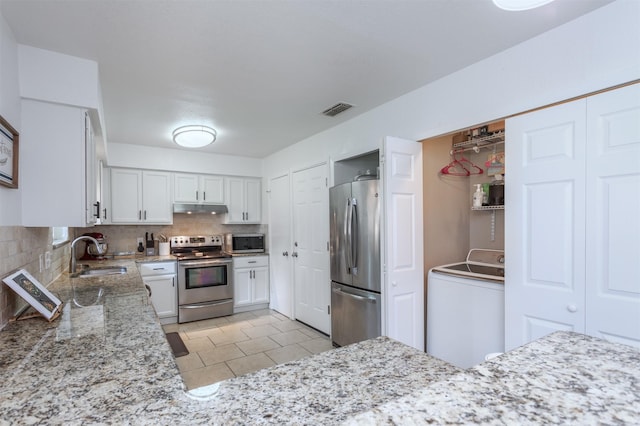 502 E Alexander Ln, Euless, TX 76040 - kitchen featuring stainless steel appliances, washer / clothes dryer, a sink, under cabinet range hood, and white cabinetry