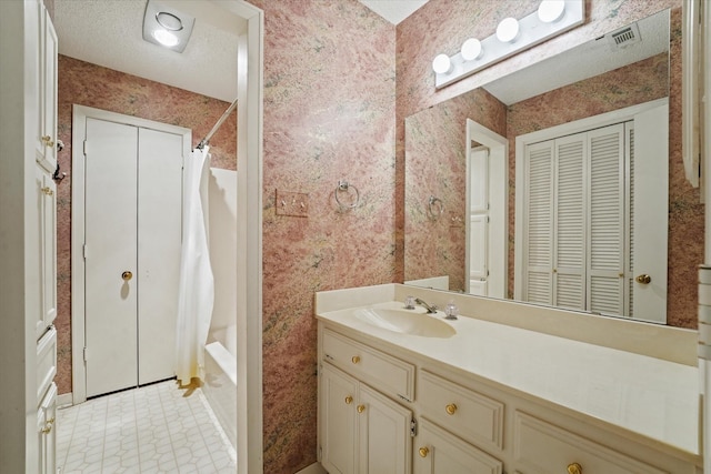 29 Timbergreen Cir, Denton, TX 76205 - full bathroom featuring wallpapered walls, vanity, shower / bathtub combination with curtain, a closet, and a textured ceiling