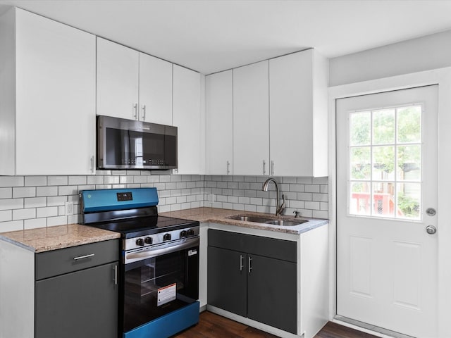 828 Ronald St, White Settlement, TX 76108 - kitchen featuring electric range, a sink, white cabinets, dark wood-style floors, and tasteful backsplash