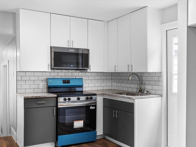 828 Ronald St, White Settlement, TX 76108 - kitchen with stainless steel electric range, a sink, white cabinetry, and decorative backsplash