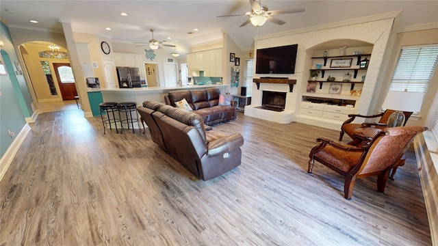 2916 Wilsonwood Way S, Sherman, TX 75092 - living area featuring arched walkways, ceiling fan, a brick fireplace, light wood finished floors, and baseboards