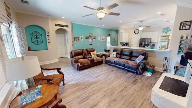 2916 Wilsonwood Way S, Sherman, TX 75092 - living area featuring ceiling fan, light wood finished floors, crown molding, arched walkways, and baseboards