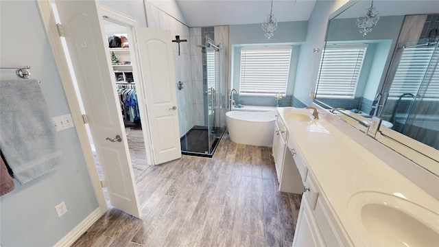 2916 Wilsonwood Way S, Sherman, TX 75092 - bathroom with double vanity, a shower stall, a freestanding bath, a spacious closet, and wood finished floors