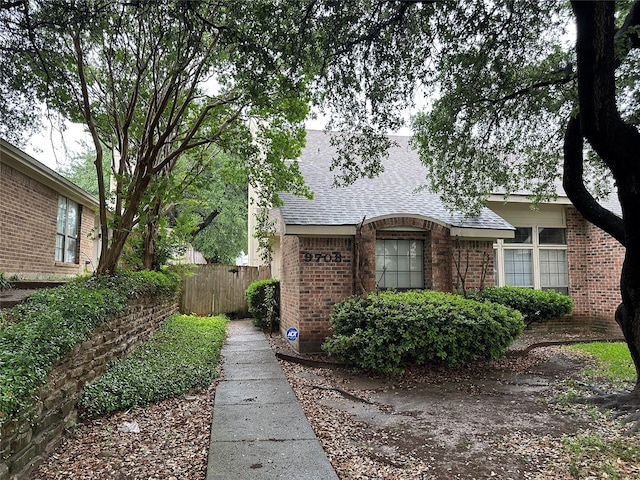 9706-9708 Springtree, Dallas, TX 75243 - view of home's exterior with brick siding and a shingled roof