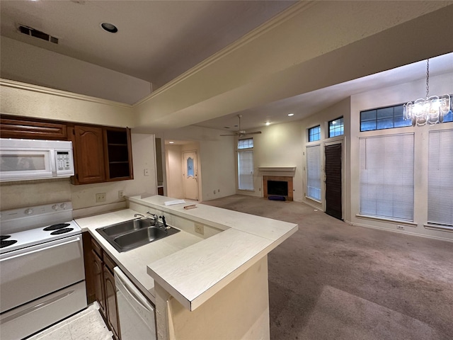 9706-9708 Springtree, Dallas, TX 75243 - kitchen featuring white appliances, a sink, a peninsula, a fireplace, and a chandelier