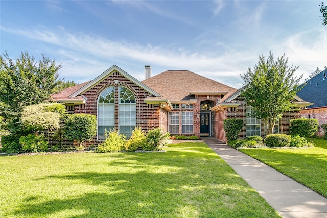 601 Natchez Ct, Hurst, TX 76054 - view of front of home featuring brick siding, a front lawn, a shingled roof, and a chimney