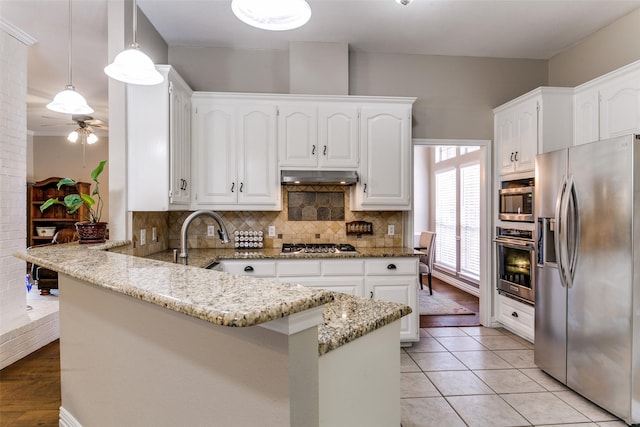 601 Natchez Ct, Hurst, TX 76054 - kitchen with appliances with stainless steel finishes, a peninsula, a ceiling fan, and white cabinetry