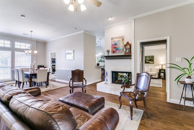 601 Natchez Ct, Hurst, TX 76054 - living area with a chandelier, ceiling fan, baseboards, a brick fireplace, and wood finished floors
