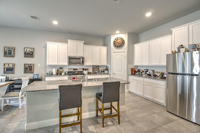 3713 Blessington Dr, Frisco, TX 75036 - kitchen featuring stainless steel appliances, decorative backsplash, white cabinets, a kitchen island with sink, and recessed lighting