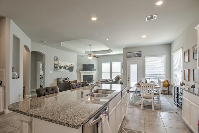 3713 Blessington Dr, Frisco, TX 75036 - kitchen featuring a sink, stainless steel dishwasher, a fireplace, arched walkways, and ceiling fan