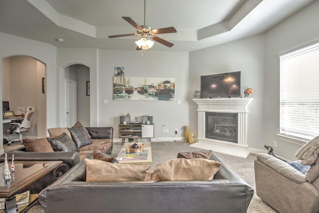3713 Blessington Dr, Frisco, TX 75036 - living room featuring arched walkways, a raised ceiling, carpet, and ceiling fan