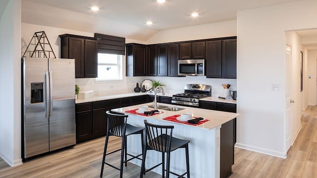 1912 Coleto Rd, Crandall, TX 75114 - kitchen with appliances with stainless steel finishes, a sink, light wood-type flooring, light countertops, and a kitchen bar