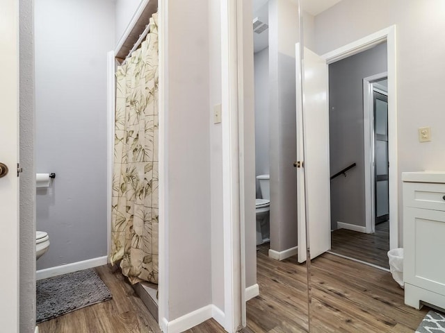 1501 N Business 45, Corsicana, TX 75110 - bathroom featuring toilet, wood finished floors, a shower with curtain, and baseboards