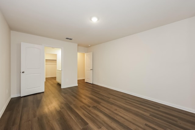 336 Bounding Main St, Gun Barrel City, TX 75156 - unfurnished bedroom with baseboards, dark wood-style flooring, and a walk in closet