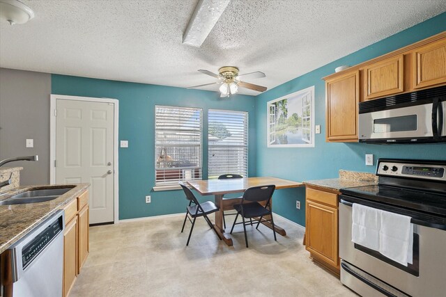 521 Ryan St, Saginaw, TX 76179 - kitchen featuring appliances with stainless steel finishes, a sink, a ceiling fan, a textured ceiling, and baseboards