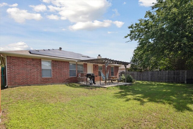 521 Ryan St, Saginaw, TX 76179 - rear view of house with a pergola, brick siding, a patio, solar panels, and a chimney