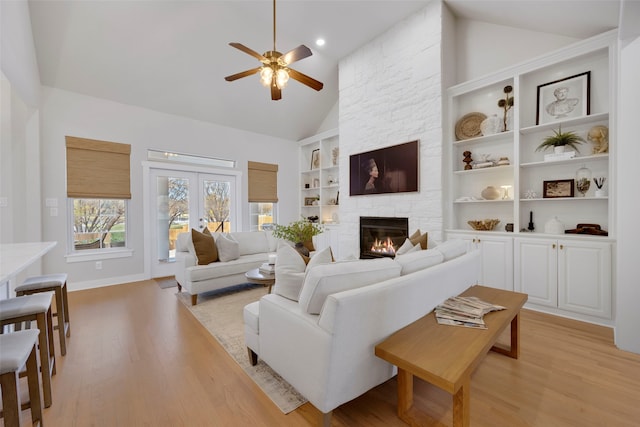6501 Glenhope Cir S, Colleyville, TX 76034 - living room with a ceiling fan, light wood-style floors, built in features, a stone fireplace, and high vaulted ceiling