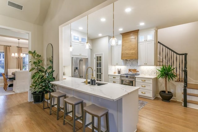 6501 Glenhope Cir S, Colleyville, TX 76034 - kitchen featuring premium appliances, a kitchen breakfast bar, light wood-style floors, a sink, and recessed lighting