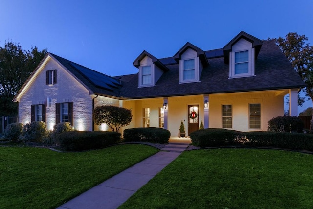 6501 Glenhope Cir S, Colleyville, TX 76034 - cape cod-style house featuring covered porch, solar panels, a front yard, brick siding, and a shingled roof