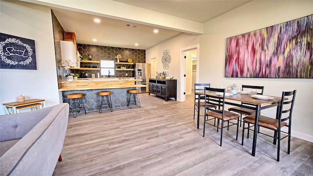 209 N Broad St, Saint Jo, TX 76265 - dining space featuring light wood finished floors, recessed lighting, beamed ceiling, and bar