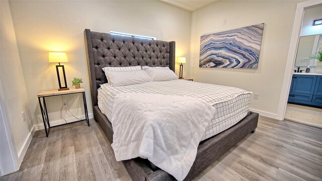 209 N Broad St, Saint Jo, TX 76265 - bedroom featuring wood finished floors, baseboards, and connected bathroom