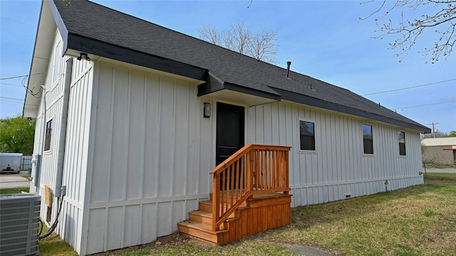 209 N Broad St, Saint Jo, TX 76265 - back of property with a shingled roof, cooling unit, and a lawn