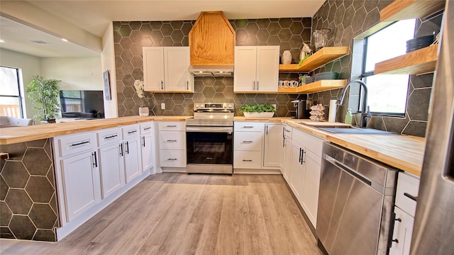 209 N Broad St, Saint Jo, TX 76265 - kitchen featuring butcher block countertops, stainless steel appliances, light wood-style flooring, a sink, and recessed lighting