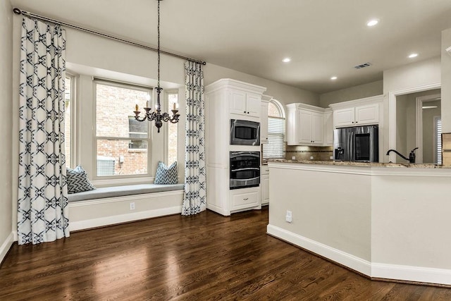 5909 Woodwind Dr, Plano, TX 75093 - kitchen with stainless steel appliances, a chandelier, white cabinets, dark wood-type flooring, and recessed lighting