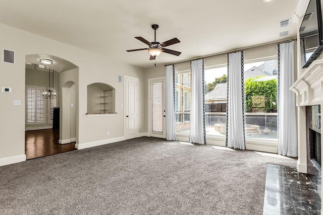 5909 Woodwind Dr, Plano, TX 75093 - unfurnished living room featuring arched walkways, a ceiling fan, carpet, a premium fireplace, and baseboards