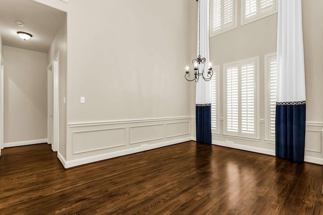 5909 Woodwind Dr, Plano, TX 75093 - unfurnished room featuring dark wood-style flooring, a wainscoted wall, a chandelier, plenty of natural light, and a decorative wall