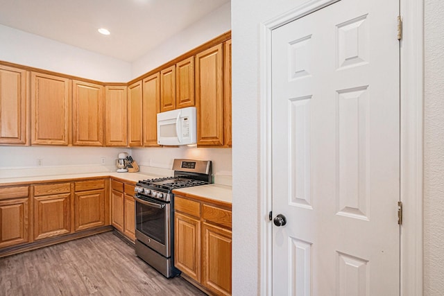 813 Royal Oak Ln, Burleson, TX 76028 - kitchen featuring white microwave, gas range, light wood-type flooring, light countertops, and recessed lighting