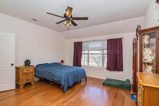 813 Royal Oak Ln, Burleson, TX 76028 - bedroom with light wood finished floors, lofted ceiling, a textured ceiling, baseboards, and ceiling fan